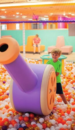 Kind an der lila Ballkanone im B&auml;llebad der Play Zone
