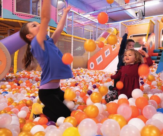 Kinder spielen mit bunten B&auml;llen im B&auml;llebad der Play Zone